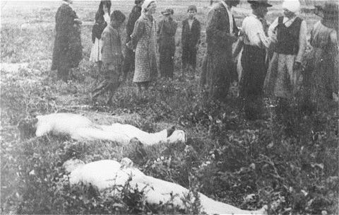 Civilians walk among the bodies that have been removed from the Iasi death train